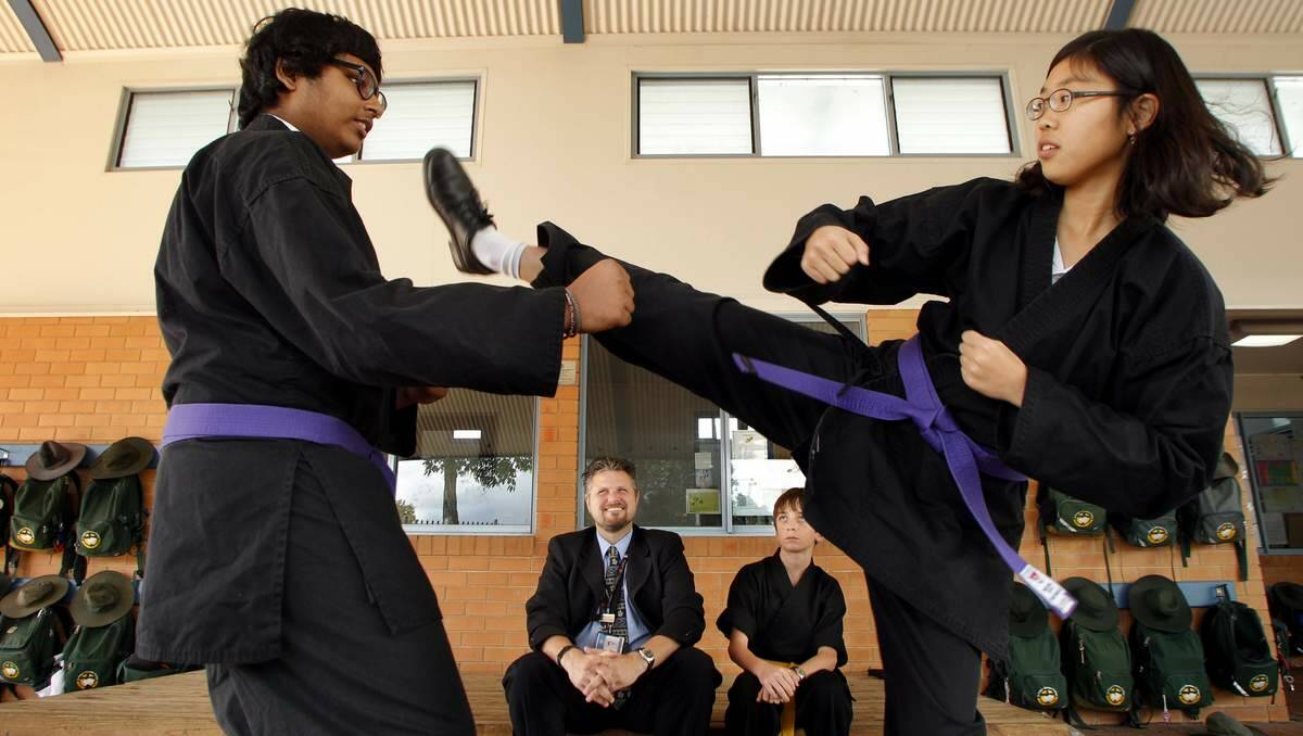 CULTURE CLASH: Stephen Grant (centre), head of St Philip’s Japanese Cultural Society, and Thomas Priest, 13, watching as Yash Gurram, 14, and Grace Kim, 14,  demonstrate some of their martial arts training. Picture: Max Mason-Hubers