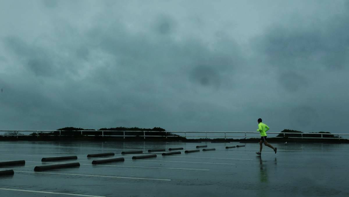 A lone jogger braving the elements on Bathers Way, Dixon Park Beach. Picture: Max Mason-Hubers