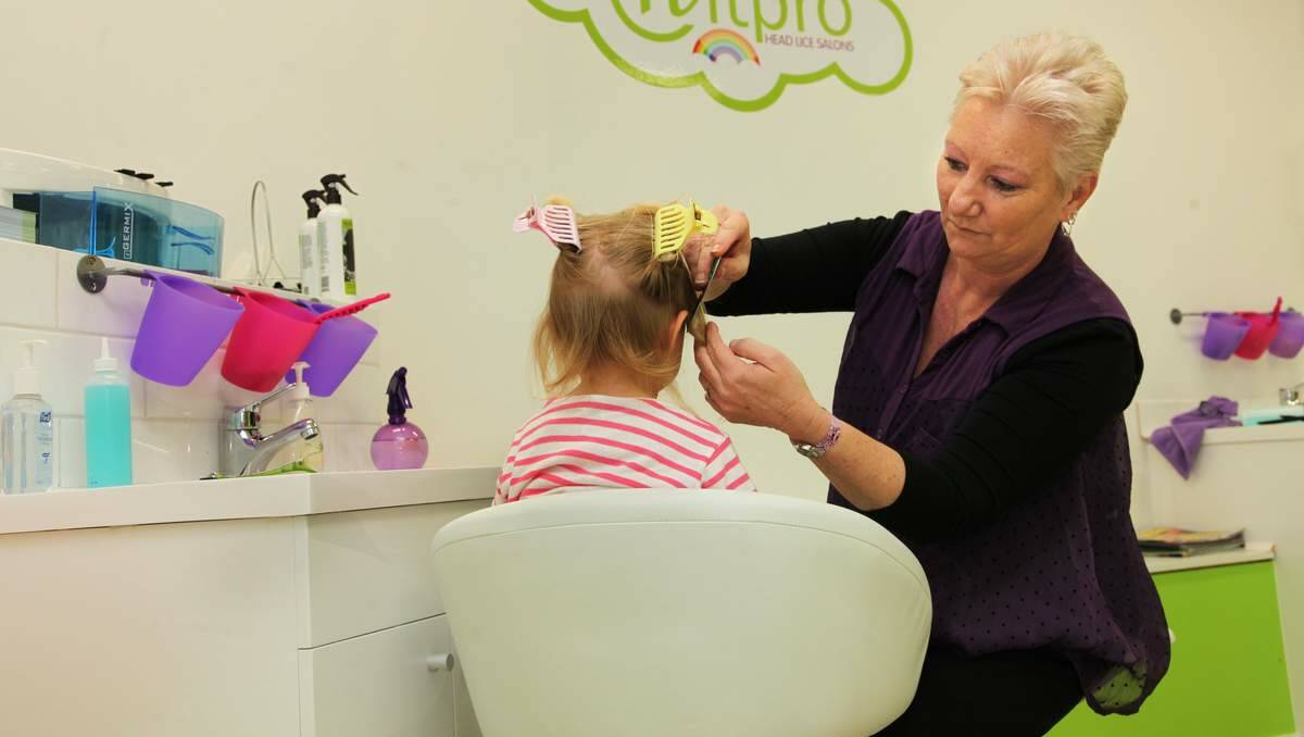 SCOURGE: Karen Way of Ziggetty Snipits treating a young girl for head lice.  Picture: Phil Hearne