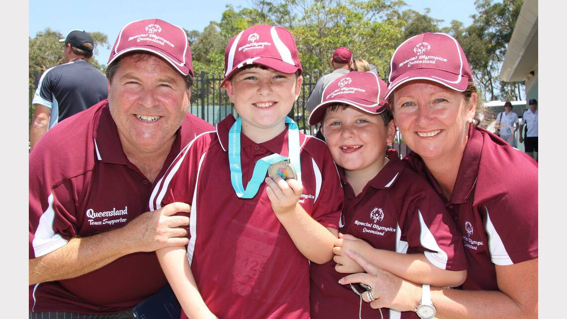 Michael Harris (QLD) proudly displays his two athletics medals to his family. Picture: Peter Muhlbock / Special Olympics Australia