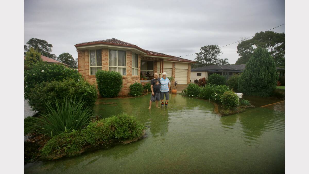 John and Genevieve Gibson stand in their front yard of their home on Dora Street, Dora Creek. Picture by Peter Stoop