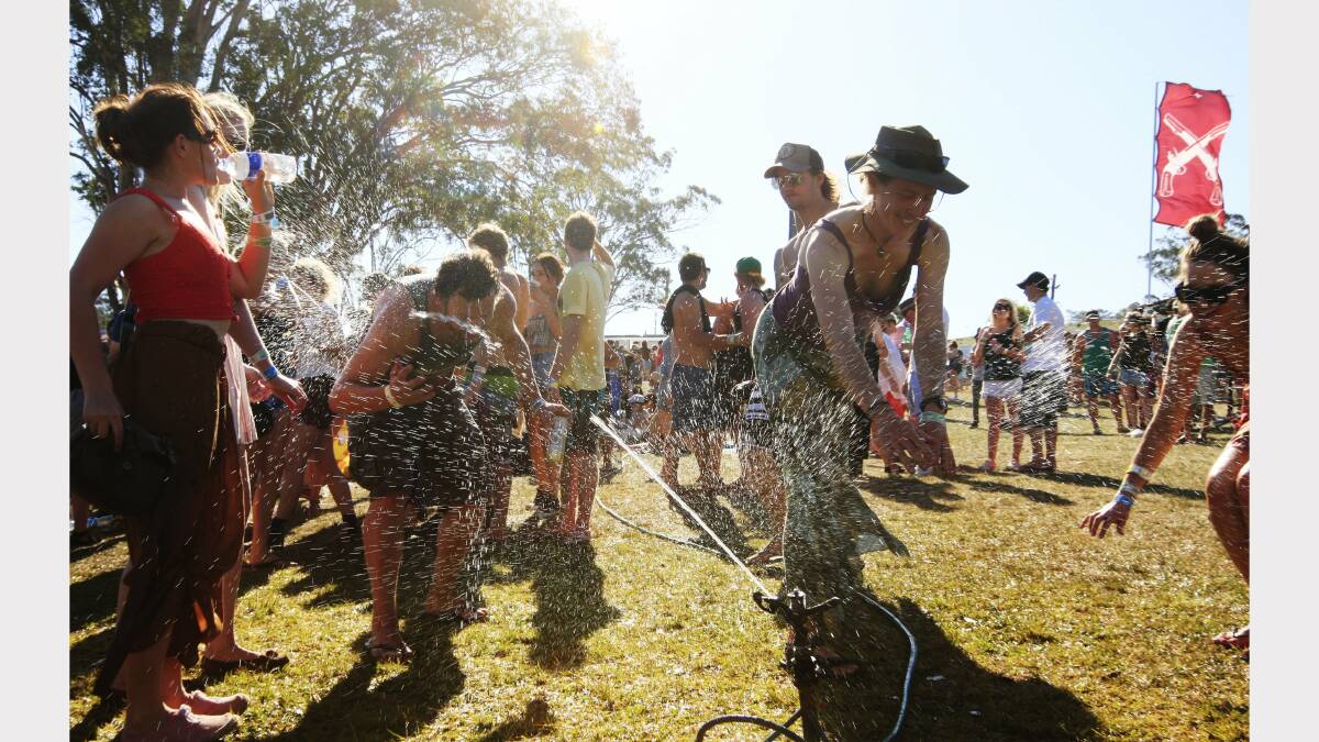 Fans cool off under the sprinkler at the Gentlemen of the Road festival at Dungog on Saturday. Picture: Peter Stoop