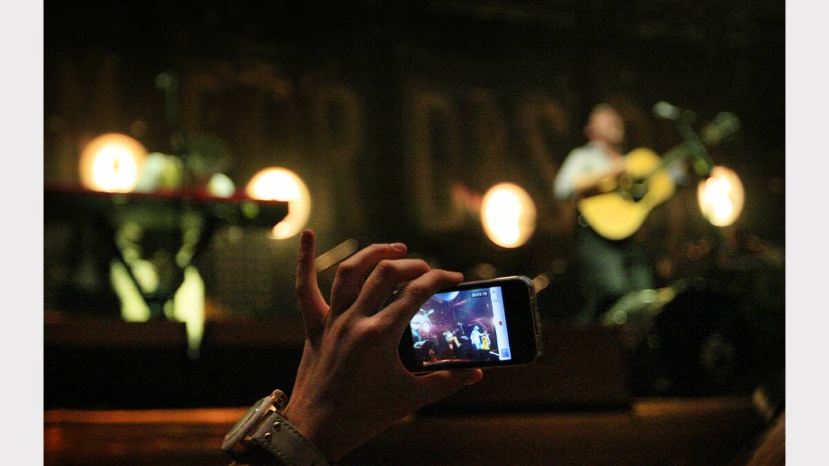 A fan records Mumford & Sons performing at the Gentlemen of the Road festival at Dungog on Saturday. Picture: Peter Stoop