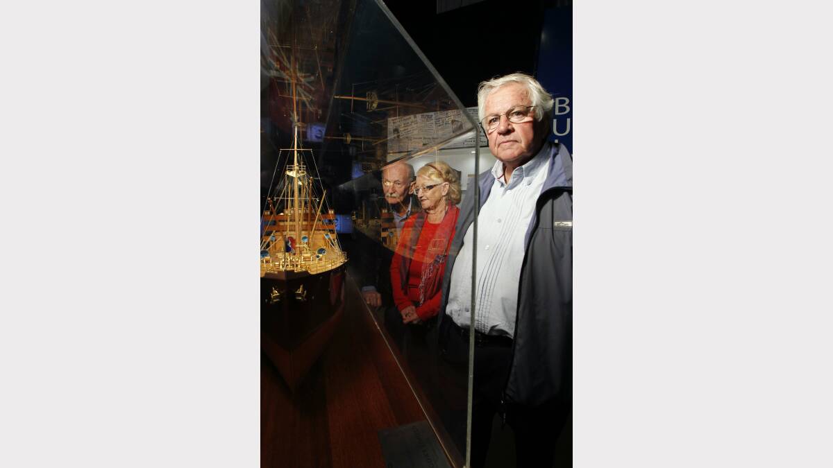 REMEMBERING: Ken Iredale, of Fletcher (centre) with Dawn Taylor, of Speers Point, and Ray Sauvan, of Gosford, at Newcastle Maritime Museum with an original model version of the Iron Knight. Picture: Max Mason-Hubers
