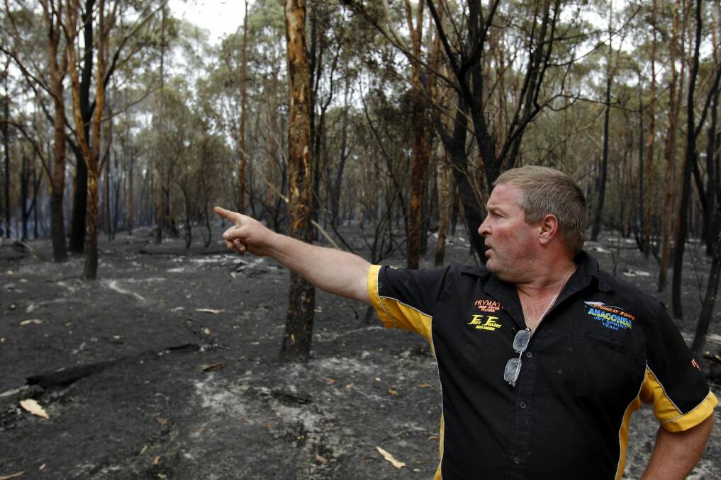 Darren Watkins, of Medowie, shows how close fire came to his shed. Picture: Max Mason-Hubers