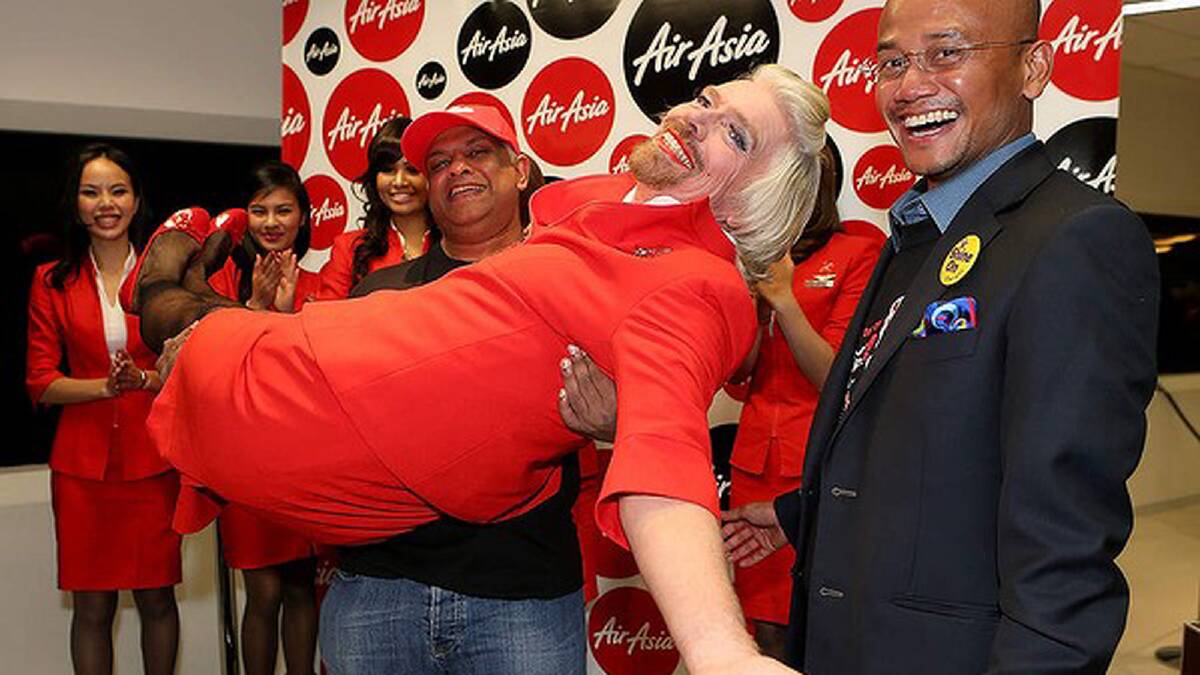 Sir Richard Branson is held in the arms of Tony Fernandes prior to their flight to Kuala Lumpur at Perth International Airport. Photo: Paul Kane