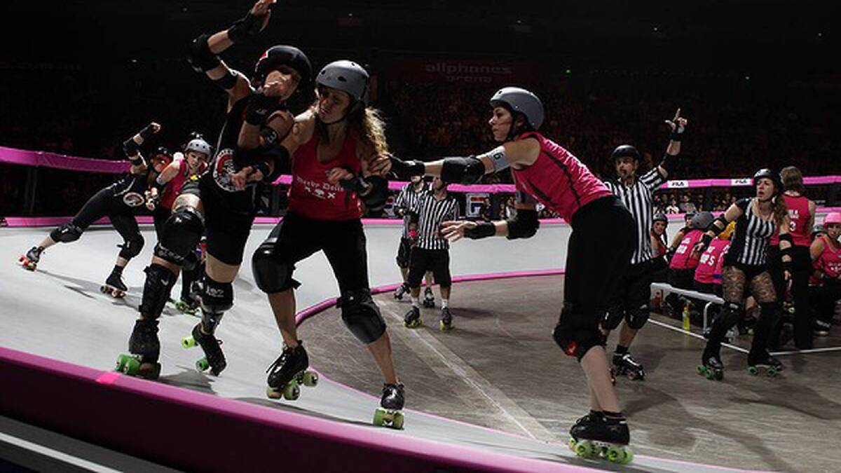 Two Derby Dolls try to stop a Gotham Girl from getting by them. Photo: Danielle Smith