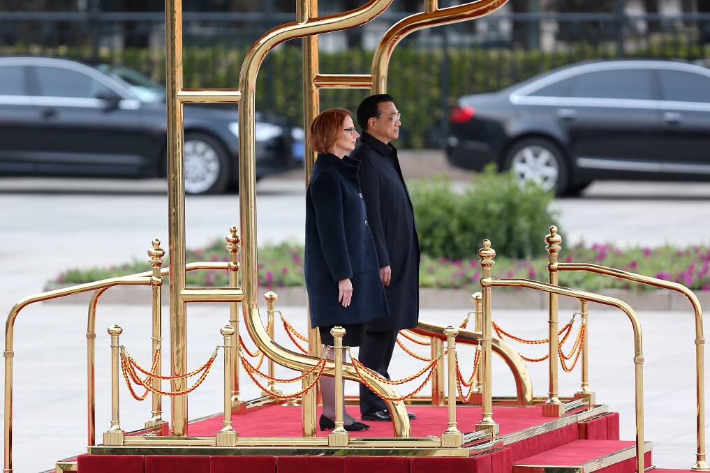 Chinese Premier Wen Jiabao and Australian Prime Minister Julia Gillard listen to their national anthems during a welcoming ceremony outside the Great Hall of the People on April 9, 2013 in Beijing, China. Photo: Getty Images